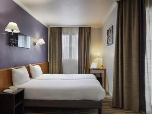 a hotel room with two beds and a window at Aparthotel Adagio La Défense Le Parc in Courbevoie +61 photos