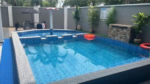 a large swimming pool with blue water in a building at LB Homestay in Lunas