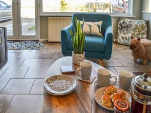 ein Wohnzimmer mit einem Tisch und Gebäck darauf in der Unterkunft Sunrise Beach in Scratby