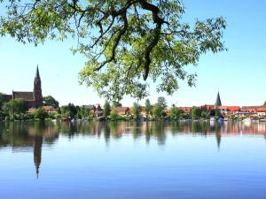 a view of a lake with a town in the background at Holiday Home Müritz Ferienpark Röbel-66 by Interhome in Marienfelde