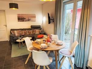 a living room with a table and chairs and a couch at Apartment Müritz Ferienpark Röbel-32 by Interhome in Marienfelde
