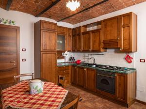 una cucina con armadi in legno e un tavolo con una tovaglia di Apartment Il Vino by Interhome a La Morra