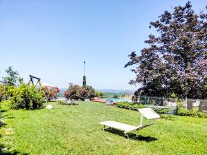 una panchina bianca seduta sull'erba in un cortile di Apartment Il Vino by Interhome a La Morra