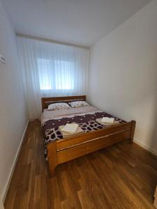 a bedroom with a bed in a room with a window at PARK NOVI Apartmani in Novi Sad