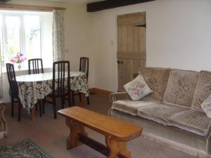 a living room with a couch and a table at East Hook Holiday Cottages - Daisy Cottage in Okehampton