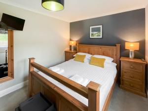 Schlafzimmer mit einem Bett mit weißer Bettwäsche und gelben Kissen in der Unterkunft St Fergus in Shiel Bridge