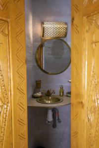 a bathroom with a sink and a mirror at Riad dar HAPPY NOCHE in Essaouira