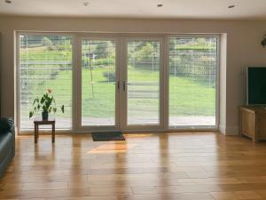an empty living room with large sliding doors at Catcleugh Bridge View in Kielder
