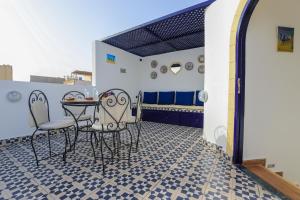 a patio with a table and chairs on a tile floor at Riad dar HAPPY NOCHE in Essaouira