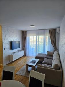a living room with a couch and a table at PARK NOVI Apartmani in Novi Sad