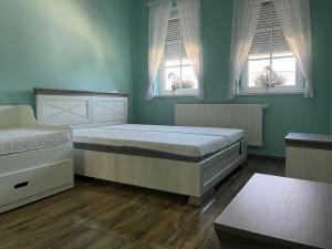 a bedroom with two beds and two windows at Napsugaras Birtok in Röszke +51 photos