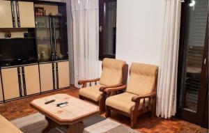 ein Wohnzimmer mit zwei Stühlen und einem Couchtisch in der Unterkunft Nice Apartment In Novi Vinodolski in Novi Vinodolski