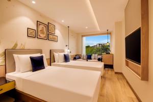 a bedroom with two beds and a large window at Keys Lite by Lemon Tree Hotels, Jaipur in Jaipur
