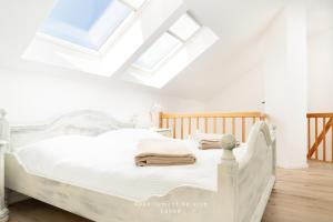 een wit bed in een kamer met dakramen bij Nautic W21 in Laboe