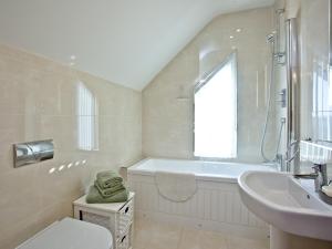 ein weißes Badezimmer mit Badewanne und Waschbecken in der Unterkunft Quantock Lodge in Chillington