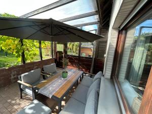 a patio with a table and chairs and an umbrella at Ferienwohnung Kapellenblick in Hallenberg