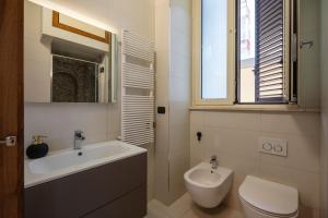 a white bathroom with a sink and a toilet at Martini Matera luxury living in Matera