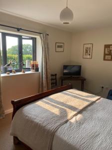 a bedroom with a bed in front of a window at Holland Park Farm in South Tawton