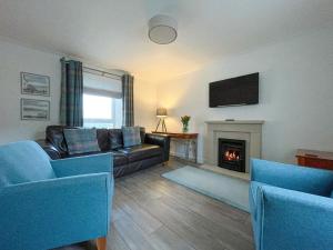 a living room with a couch and a fireplace at Willow Cottage in Sandwick