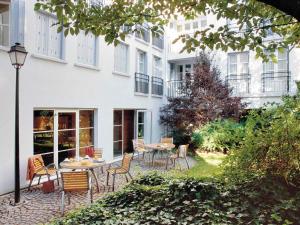 a patio with chairs and a table in front of a building at Aparthotel Adagio Paris Montmartre in Paris