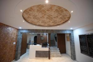 a lobby with a circular ceiling and stairs at Hotel Film Suites in Hyderabad