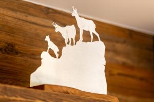 a wooden sign with three deer on a wall at Le Chamois l Ski-out l Standing in Siviez