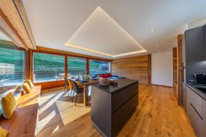 a kitchen and dining room with a large window at Le Chamois l Ski-out l Standing in Siviez