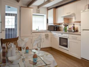 una cocina con una mesa con gafas. en Horseshoe Cottage, en Fife