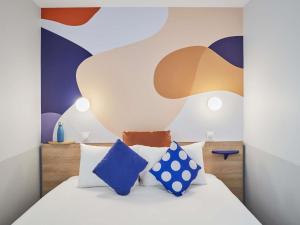 Ένα ή περισσότερα κρεβάτια σε δωμάτιο στο Aparthotel Adagio Val d'Europe près de Disneyland Paris