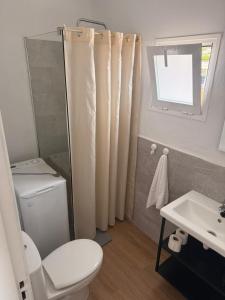 a bathroom with a toilet and a sink and a window at Sabbia Suites Casa Vera in Teguise