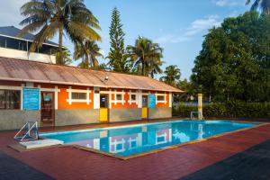 a house with a swimming pool in front of a building at Renai Blue Waters Cherai in Cherai Beach