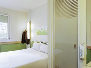 a bedroom with a bed and a sliding glass door at Ibis Budget Oviedo in Oviedo