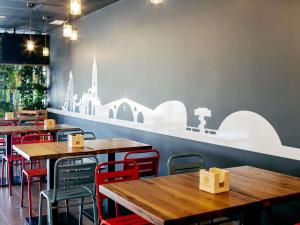a restaurant with wooden tables and red chairs at Ibis Budget Oviedo in Oviedo
