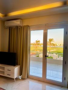 un salon avec une porte coulissante en verre et une télévision dans l'établissement Royal Nile Villa - Luxury Nile Sky Penthouse 1, à Al Aqālitah 15 autres photos