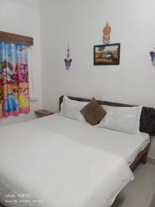 a bedroom with a large white bed with white pillows at Yoga homestay in Khajurāho