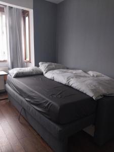 an unmade bed in a room with a window at Private room with shared bathroom in Northolt