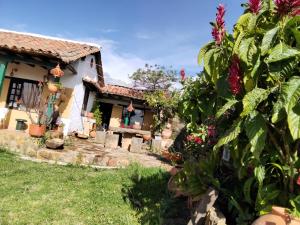 a house with a garden in front of it at POSADA VILLA DEL ROSARiO in Sutamarchán