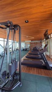 un gimnasio con una fila de máquinas de correr en un edificio en Hospede-se com charme e praticidade no Meireles, en Fortaleza