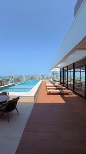 un gran edificio con piscina, mesas y sillas en Hospede-se com charme e praticidade no Meireles, en Fortaleza