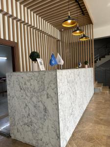 a lobby with a marble counter with potted plants at Elite World GO İnegöl in Inegol