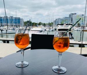 two glasses of wine sitting on a table near a marina at Edelstein am Meer in Damp