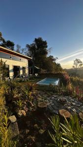 a house with a swimming pool in a yard at Villagio vilas boas Monte Verde in Camanducaia