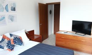 una camera da letto con un letto e una TV a schermo piatto di Alle Terme B&B Poesia a Rapolano Terme
