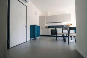 a kitchen with a blue cabinet and a table with chairs at Phi Apartments Bergamo in Nembro