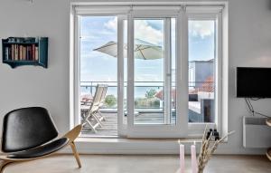 a living room with a sliding glass door to a balcony with an umbrella at Amazing Apartment In Gudhjem With Wifi in Gudhjem