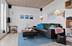 a living room with a black leather couch and a blue rug at Amazing Apartment In Gudhjem With Wifi in Gudhjem