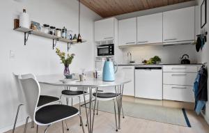 a kitchen with white cabinets and a table and chairs at Amazing Apartment In Gudhjem With Wifi in Gudhjem