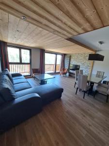 Una sala de estar con un sofá azul y una mesa. en Chalet des Neiges -La Source des Arcs, en Arc 2000 75 fotos más