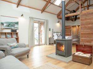 a living room with a wood stove in it at The Wheel Loft in Marldon
