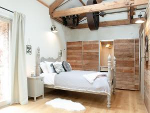a bedroom with a white bed and wooden walls at The Wheel Loft in Marldon